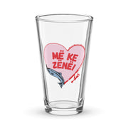 Clear pint glass with fishing heart design and Albanian text “Më ke zënë.”