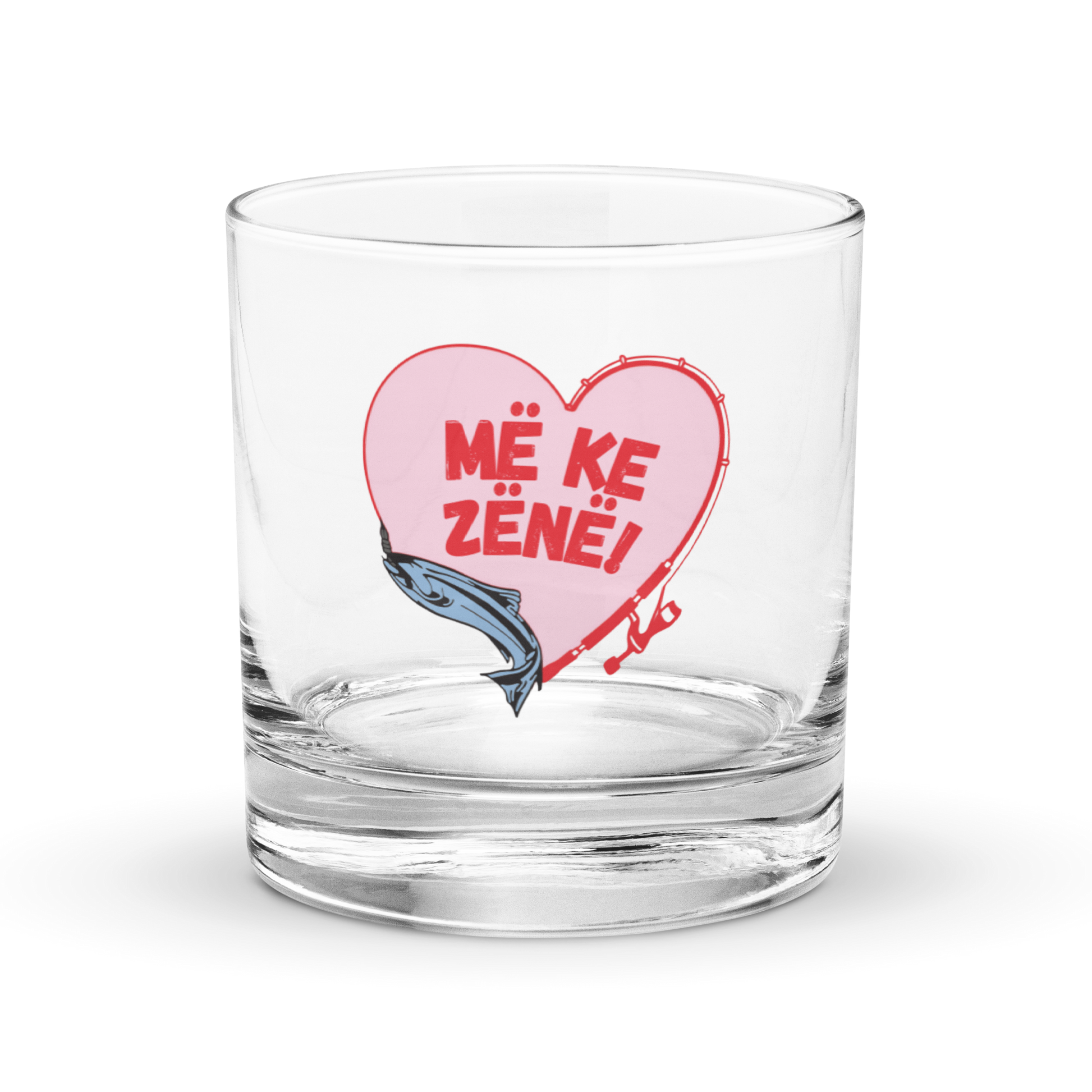 Clear rocks glass with fishing heart design and Albanian text “Më ke zënë.”