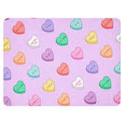 Lavender blanket with colorful sweetheart-style candy hearts and Albanian love phrases.