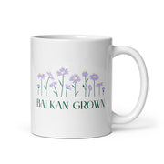 White mug with purple wildflowers and the phrase “Balkan Grown.”