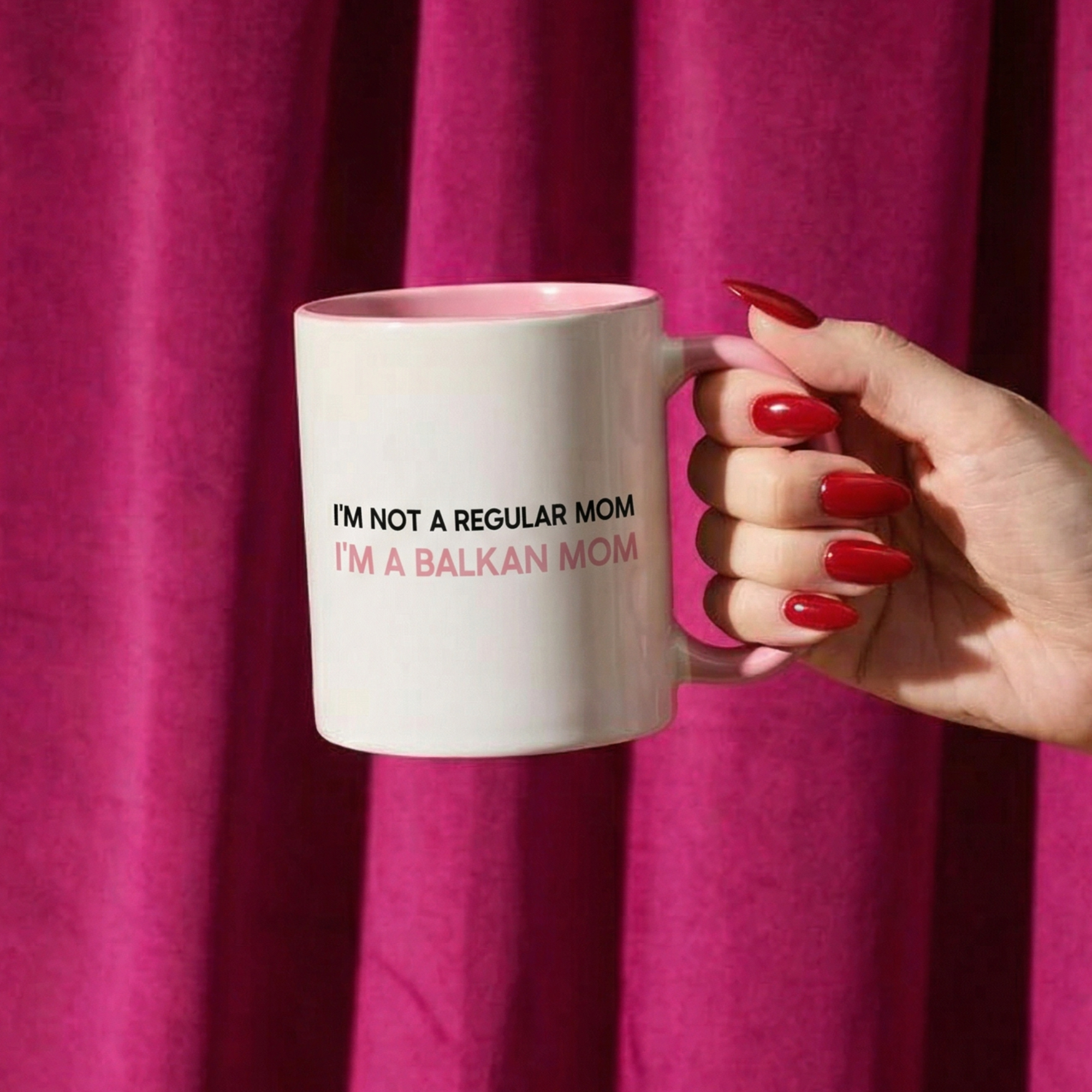 White mug with pink handle reading “I’m not a regular mom, I’m a Balkan mom.”