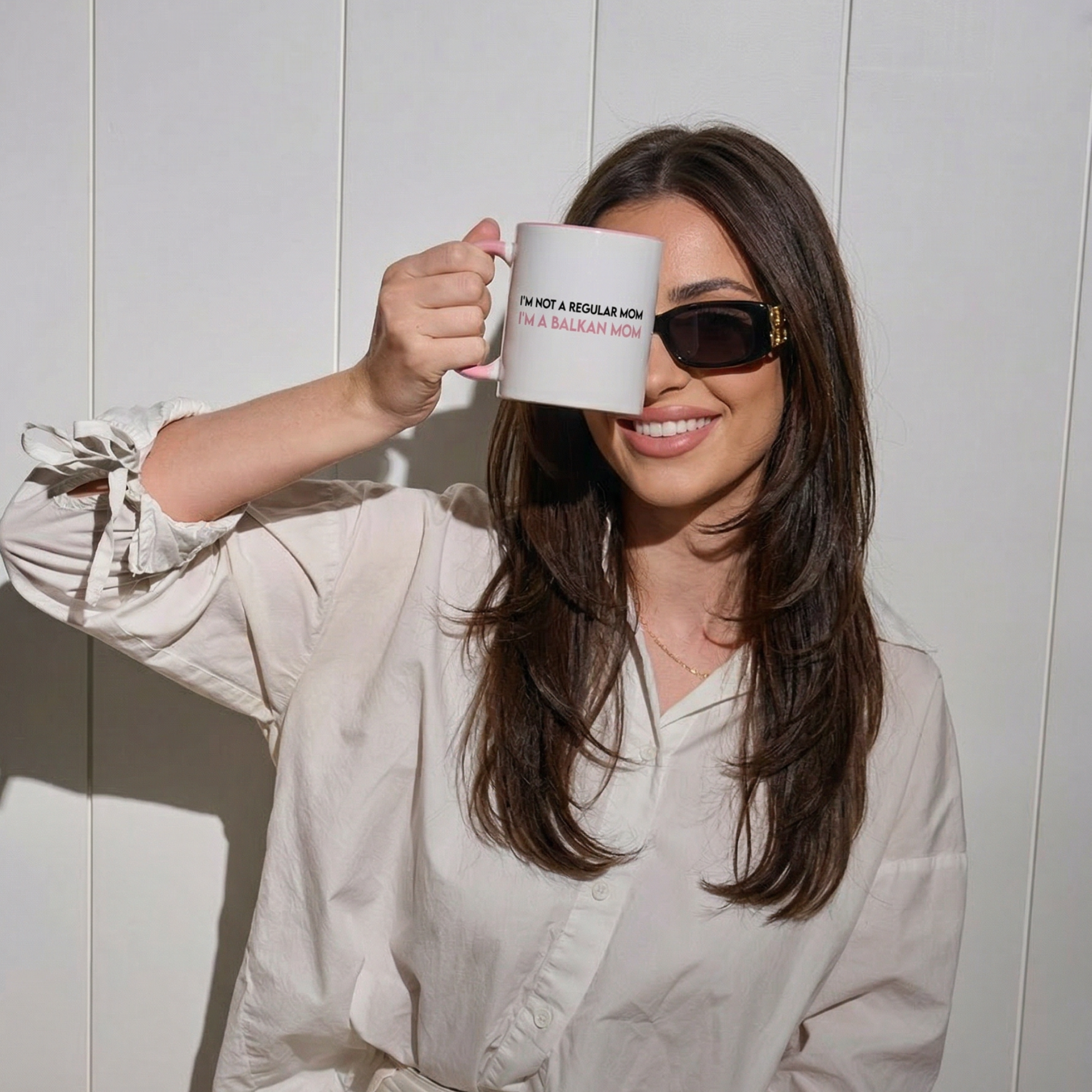 White mug with pink handle reading “I’m not a regular mom, I’m a Balkan mom.”