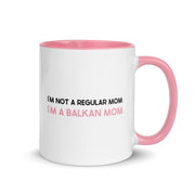 White mug with pink handle reading “I’m not a regular mom, I’m a Balkan mom.”
