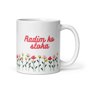 White mug with red text reading “Radim ko stoka” above colorful flowers.