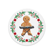 Balkan gingerbread man ornament playing keyboard with Christmas floral wreath.