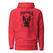 Red hoodie featuring black Albanian double-headed eagle and patriotic phrase “Rrënjët e mia rrjedhin kuq e zi.”