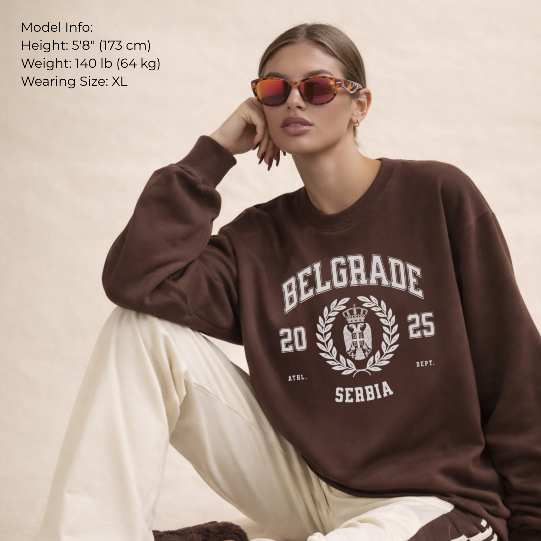 Person wearing a brown sweatshirt with 'Belgrade 2025 Serbia' text, sitting against a neutral background.
