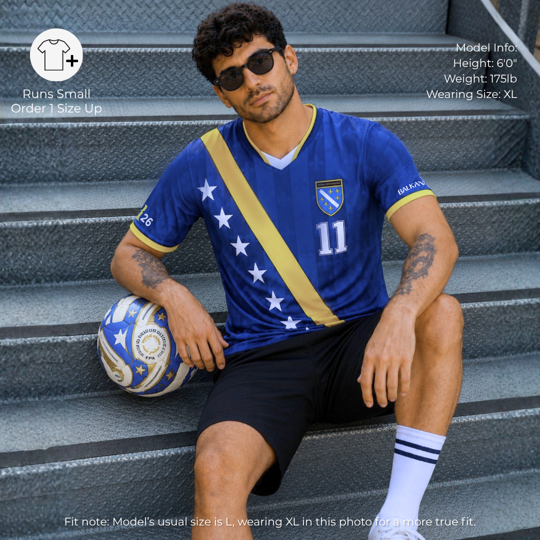 Man wearing Bosnia-inspired football jersey holding soccer ball in casual stadium-inspired setting