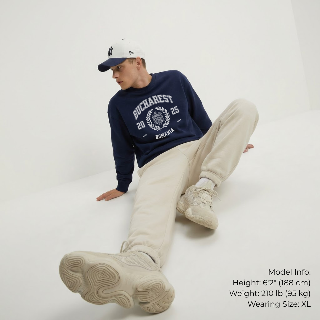 Person wearing a navy sweater with text, beige pants, and white sneakers on a white background