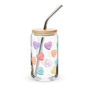 Glass can cup with colorful sweetheart candy hearts and romantic phrases.