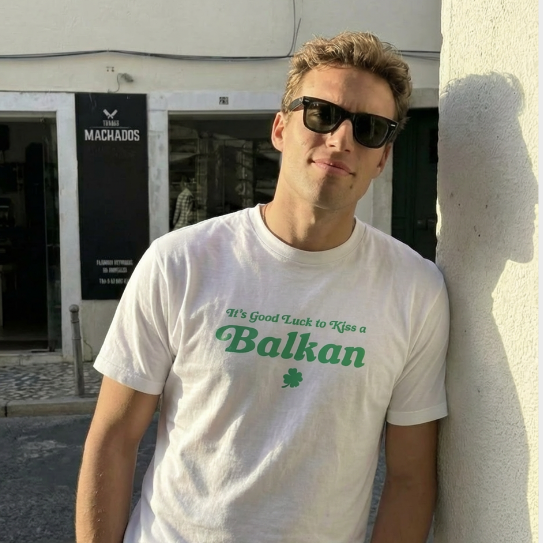 photo of a young man wearing sunglasses and "it's good luck to kiss a Balkan" t-shirt in white