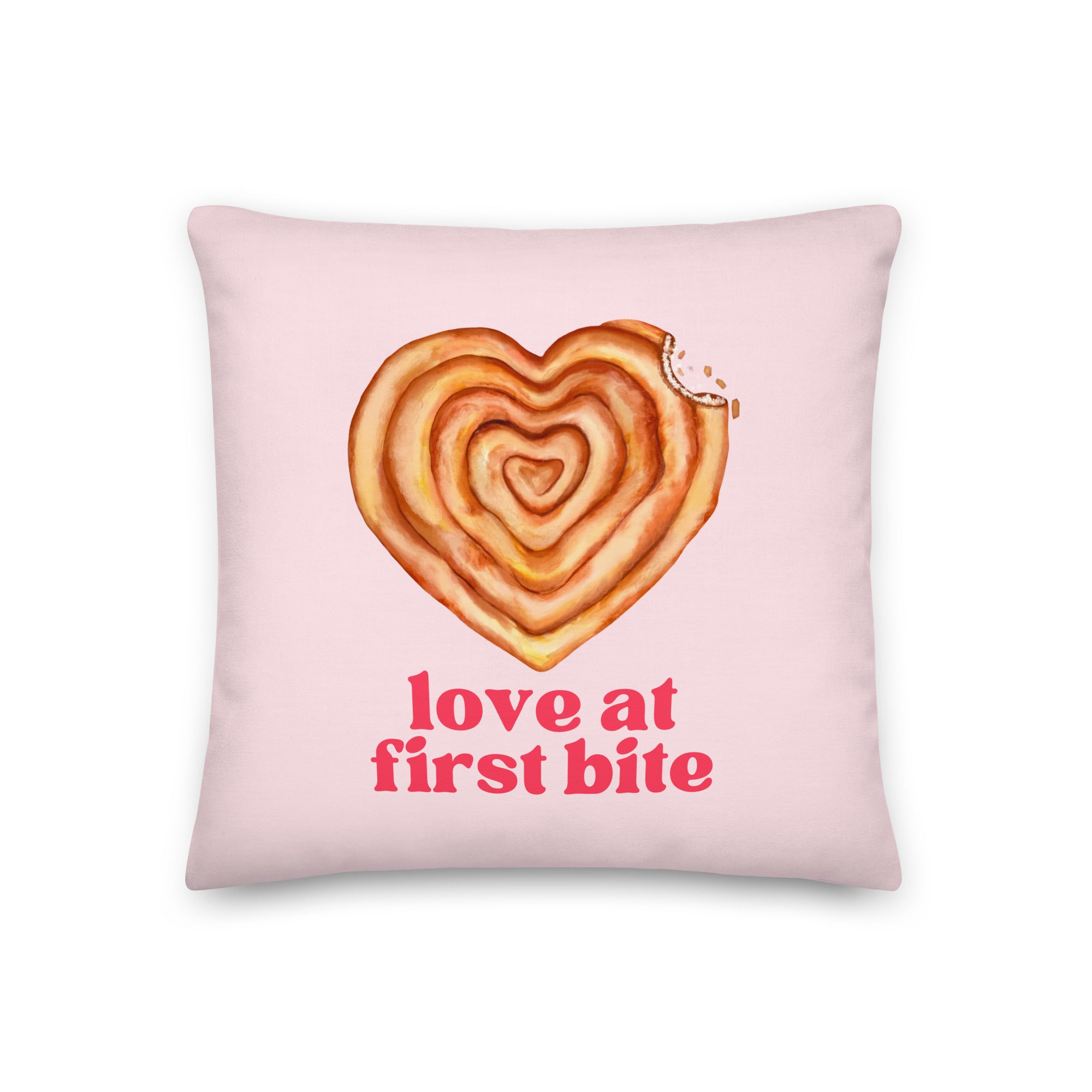 Pillow with text “Love at First Bite” and a heart-shaped burek with a bite taken out