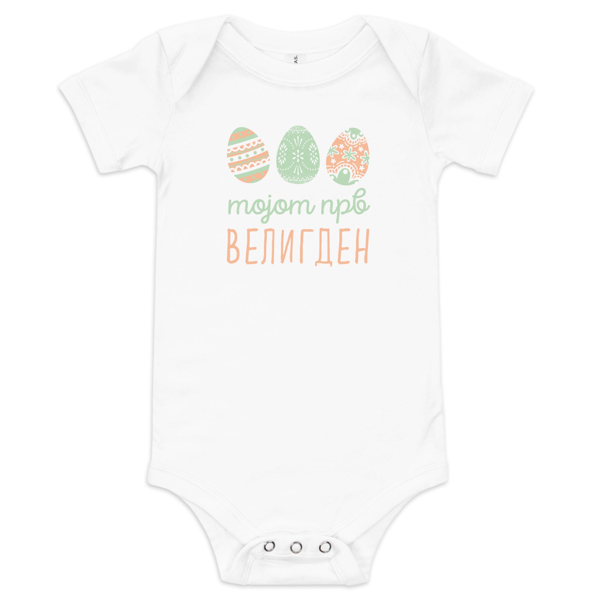 Macedonian baby bodysuit with pastel Easter eggs and the phrase “Мојот прв Велигден” meaning My First Easter in Macedonian