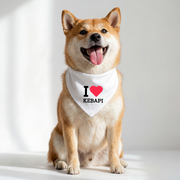Dog wearing a bandana with 'I ❤️ Kebapi' text on a white background