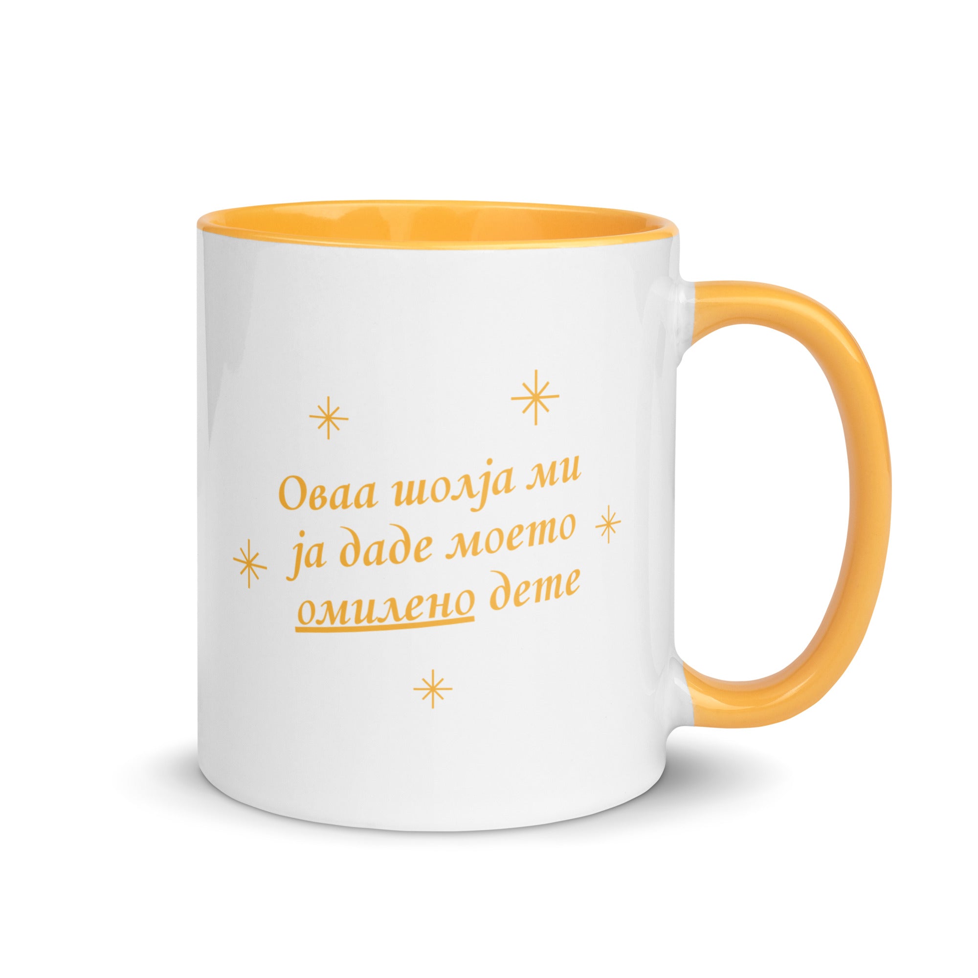 White mug with yellow handle reading “Оваа шолја ми ја даде моето омилено дете.”