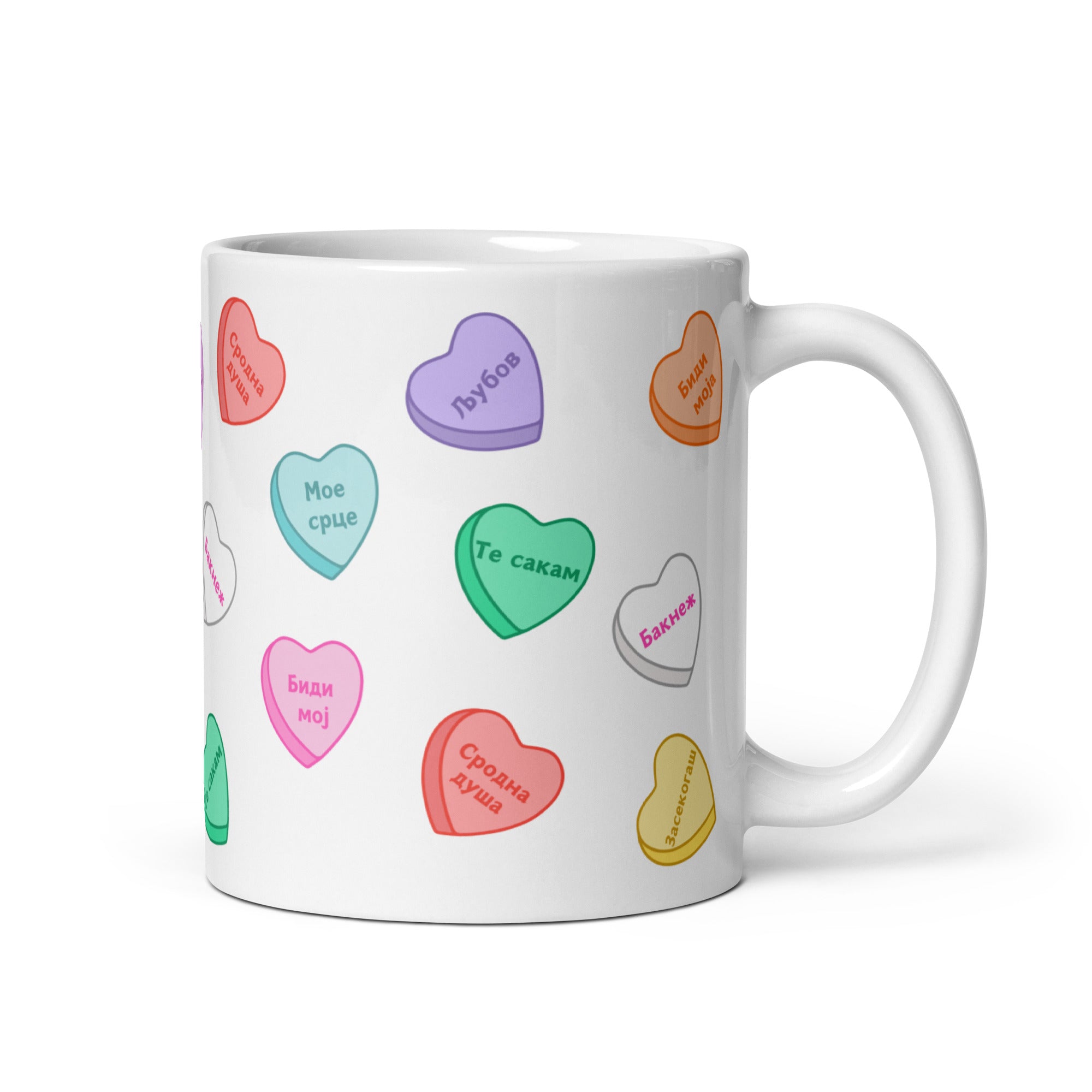 White mug with colorful Macedonian Sweethearts-style candy hearts and love phrases.