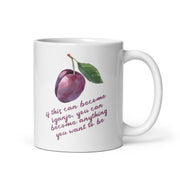 White mug with watercolor plum illustration and quote reading “If this can become žganje, you can become anything you want to be.”