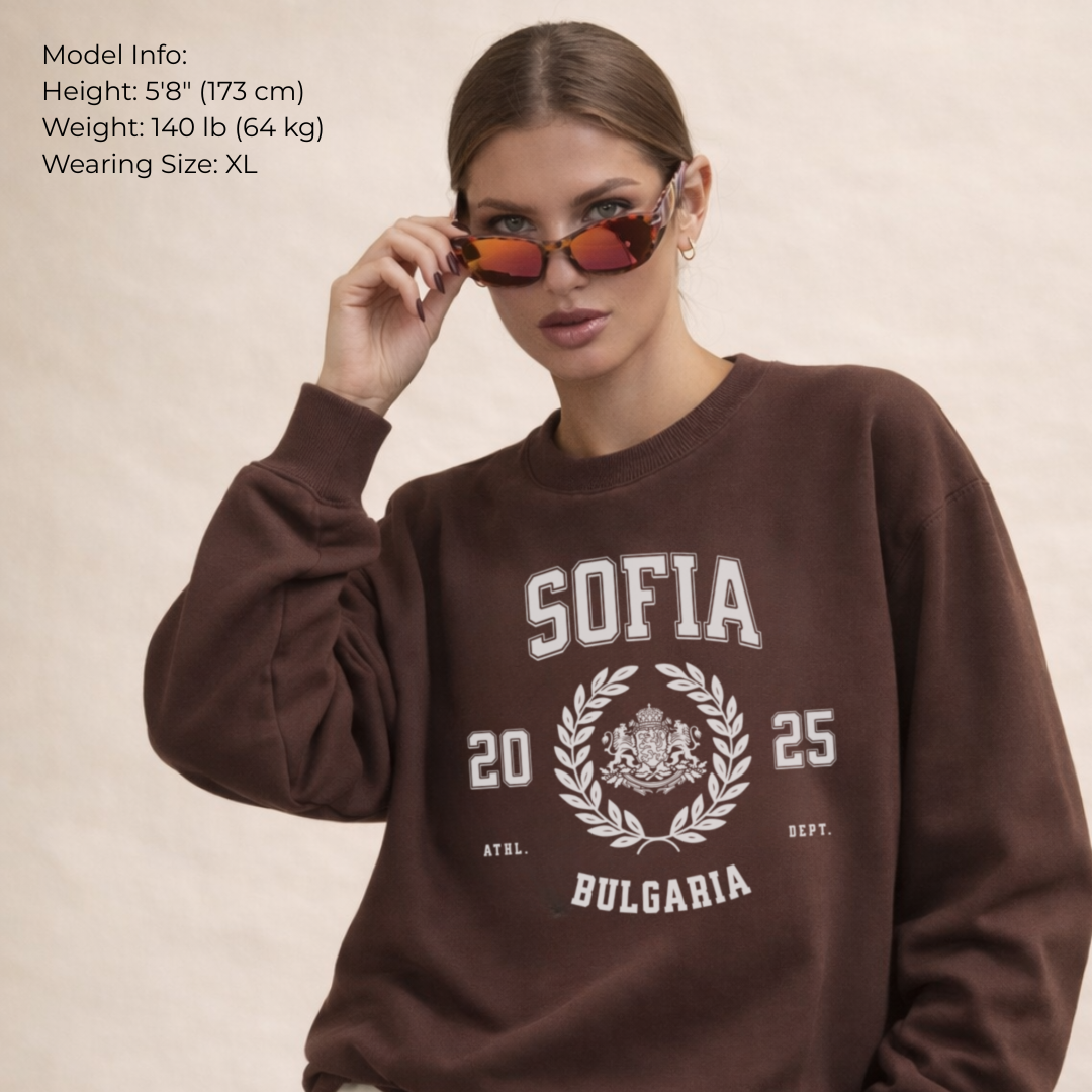 Woman wearing a brown sweatshirt with 'Sofia Bulgaria' text and design, holding sunglasses.